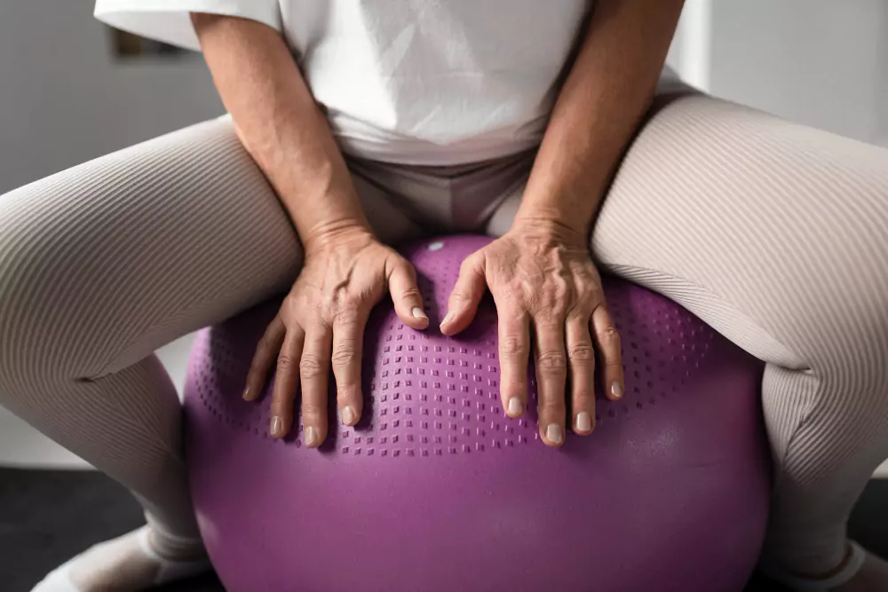 Uma mulher idosa está se exercitando com uma bola na academia